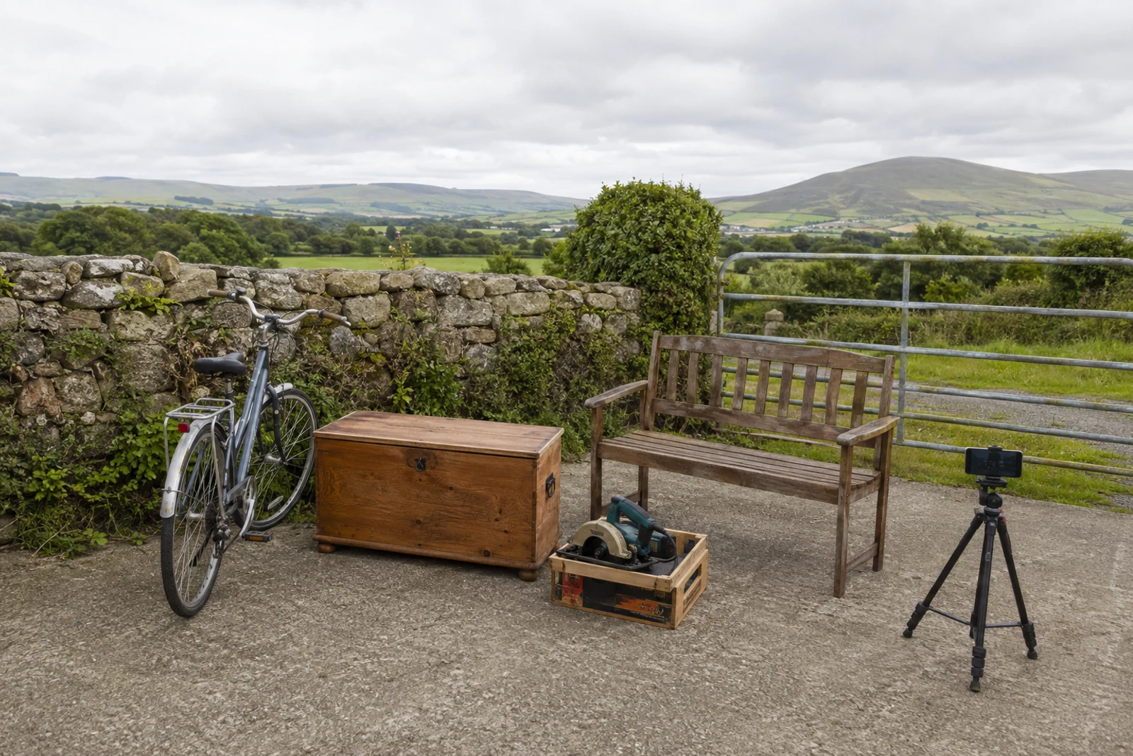 Second-hand bicycle, chest and tools arranged beside a rural Donegal landscape