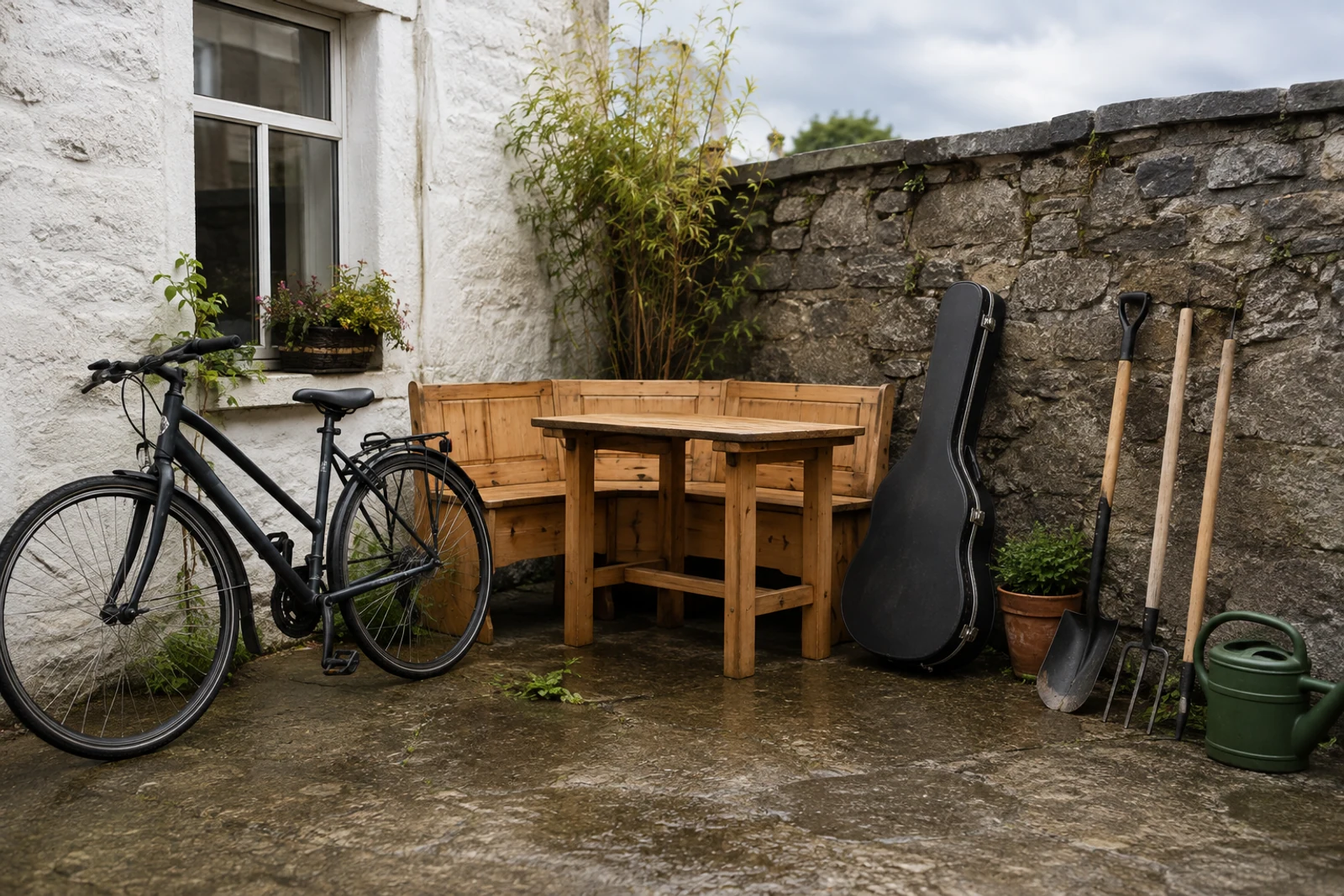Bicycle, furniture and garden items arranged for sale beside a Galway stone wall